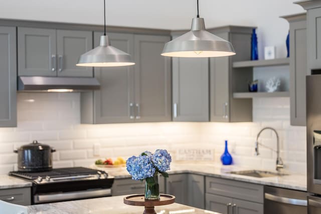 kitchen with decorative light fixtures, sink, decorative backsplash, and appliances with stainless steel finishes