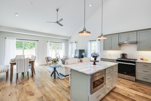 kitchen featuring gray cabinets, backsplash, a center island, and appliances with stainless steel finishes