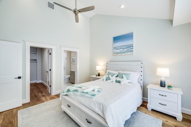 bedroom with light hardwood / wood-style flooring, ceiling fan, ensuite bathroom, a spacious closet, and a closet