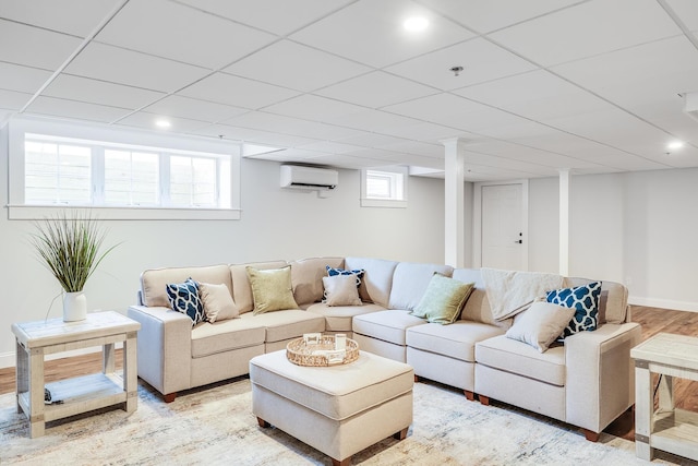 living room with light wood-type flooring, a wall mounted air conditioner, and a wealth of natural light