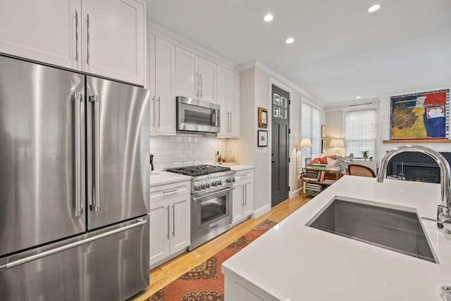 350 Bradford St Unit U7, Provincetown, MA 02657 - kitchen with premium appliances, a sink, recessed lighting, light wood-style floors, and white cabinets