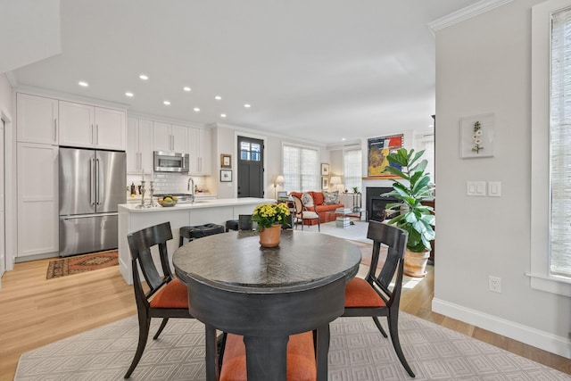 350 Bradford St Unit U7, Provincetown, MA 02657 - dining space with ornamental molding, light wood-style flooring, a glass covered fireplace, baseboards, and recessed lighting