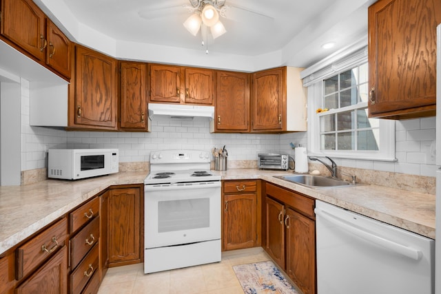 kitchen featuring a sink, light countertops, under cabinet range hood, white appliances, and a ceiling fan
