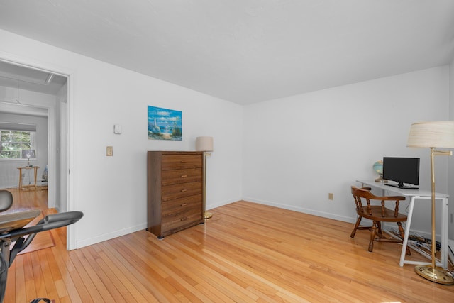 office space with baseboards, attic access, and light wood-style floors
