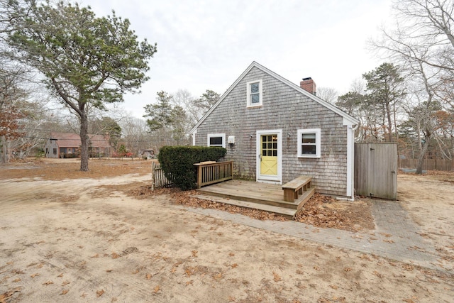 back of house featuring a chimney and a wooden deck