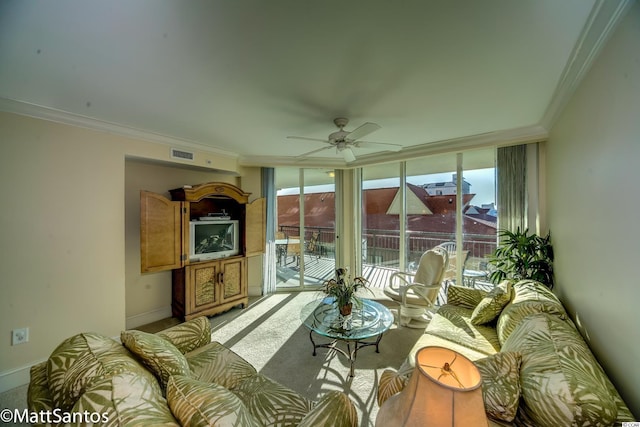 living room with ornamental molding, light colored carpet, and ceiling fan