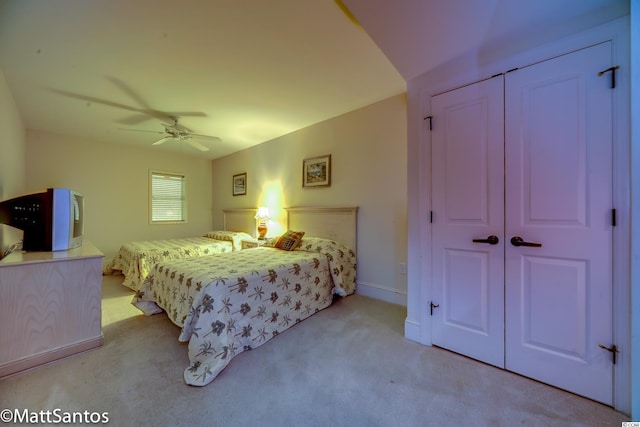 carpeted bedroom with ceiling fan and a closet