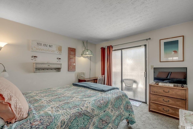 bedroom featuring light colored carpet and a textured ceiling