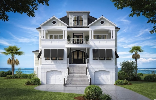 view of front of home featuring a balcony, a water view, a front yard, and a garage