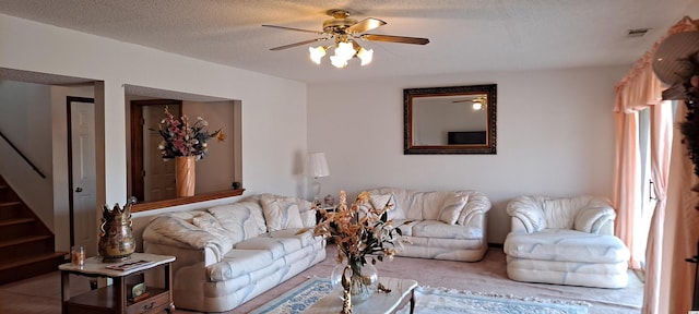 living room with ceiling fan and a textured ceiling