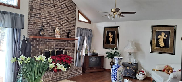 living room featuring a brick fireplace, a healthy amount of sunlight, dark hardwood / wood-style flooring, and vaulted ceiling