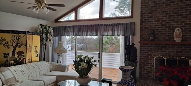 living room with ceiling fan, a fireplace, and vaulted ceiling