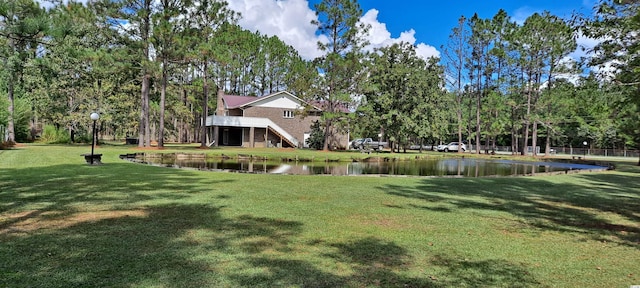 view of home's community with a lawn and a water view