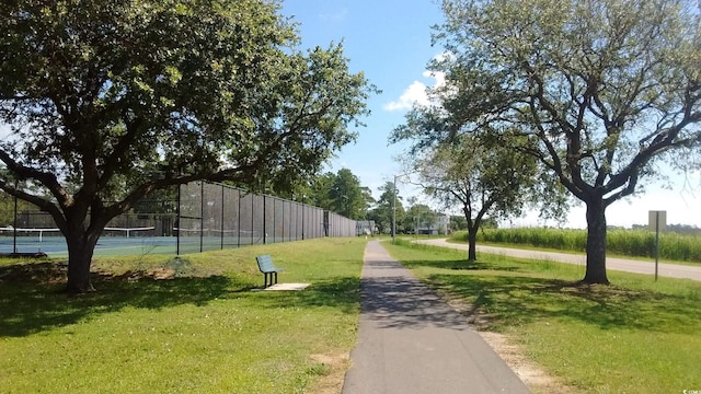 view of community featuring tennis court