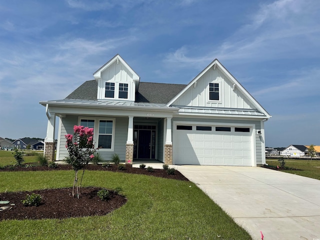 1228 Colusa Ct, Little River, SC 29566 - view of front of property with board and batten siding, concrete driveway, a front lawn, and covered porch