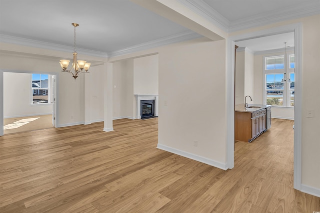 1228 Colusa Ct, Little River, SC 29566 - unfurnished dining area featuring plenty of natural light, crown molding, a chandelier, light wood finished floors, and a glass covered fireplace