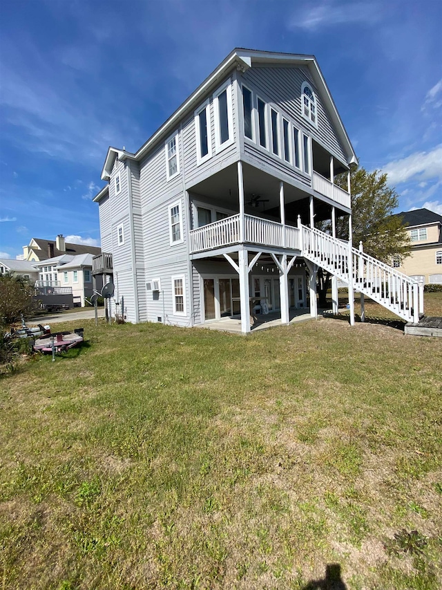 rear view of property with ceiling fan and a yard