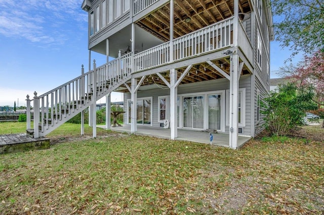 exterior space featuring a wooden deck, a lawn, and a patio