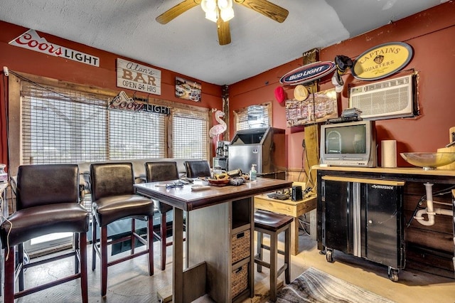 interior space with a textured ceiling and ceiling fan