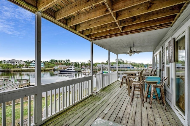 wooden terrace featuring a water view and ceiling fan