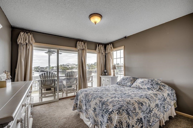 carpeted bedroom featuring a textured ceiling and access to outside