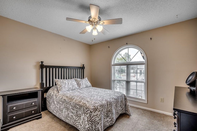 carpeted bedroom featuring a textured ceiling and ceiling fan