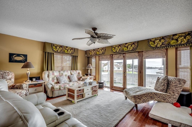 living room with hardwood / wood-style flooring, a textured ceiling, ceiling fan, and a wealth of natural light