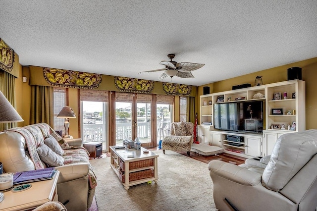 living room featuring ceiling fan, carpet flooring, french doors, and a textured ceiling