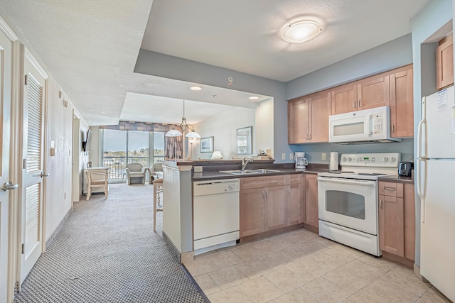 kitchen with decorative light fixtures, light carpet, kitchen peninsula, white appliances, and sink