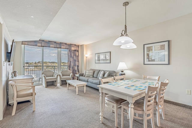 dining area featuring lofted ceiling and carpet