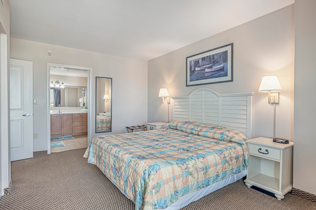 bedroom with ensuite bathroom and dark colored carpet