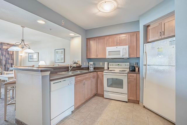 kitchen with kitchen peninsula, white appliances, sink, light tile floors, and decorative light fixtures