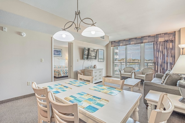 dining area featuring an inviting chandelier, a textured ceiling, and light colored carpet