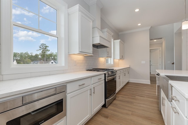 kitchen featuring white cabinets, light stone counters, and appliances with stainless steel finishes