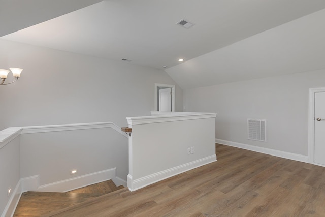 bonus room with lofted ceiling and hardwood / wood-style floors