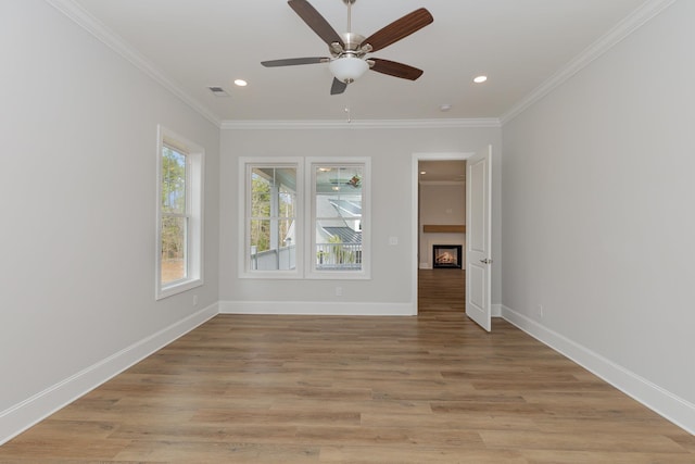 unfurnished room featuring ceiling fan, crown molding, and light hardwood / wood-style flooring