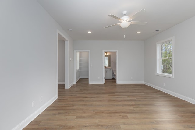 unfurnished bedroom featuring a closet, ensuite bathroom, ceiling fan, and light hardwood / wood-style floors