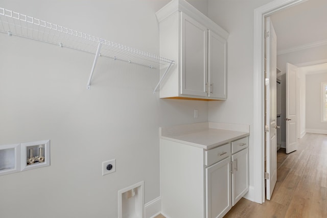 laundry area featuring hookup for an electric dryer, hookup for a washing machine, light wood-type flooring, cabinets, and crown molding