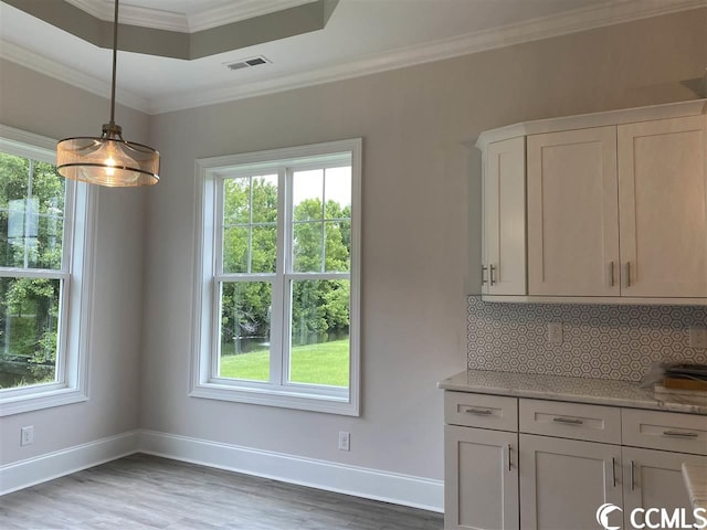 kitchen featuring backsplash, a wealth of natural light, and hardwood / wood-style floors