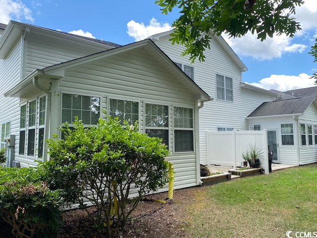 rear view of property featuring a lawn