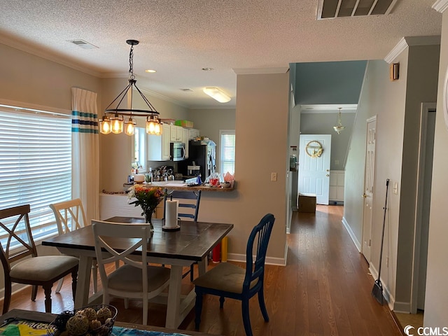 dining space featuring a chandelier, a textured ceiling, dark hardwood / wood-style floors, and crown molding