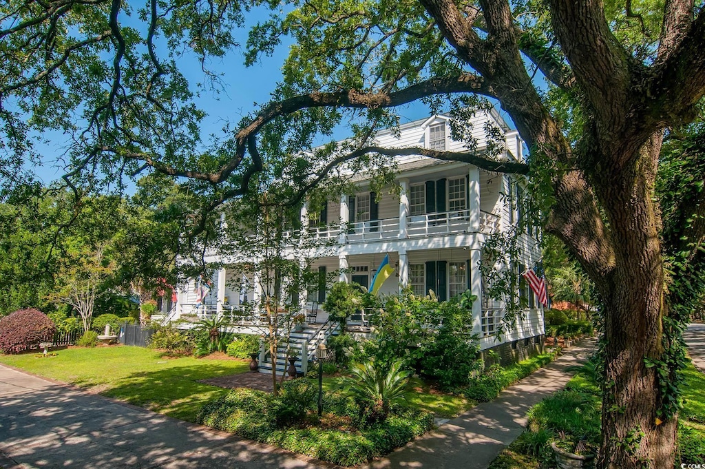 view of front of property with a front lawn and a balcony