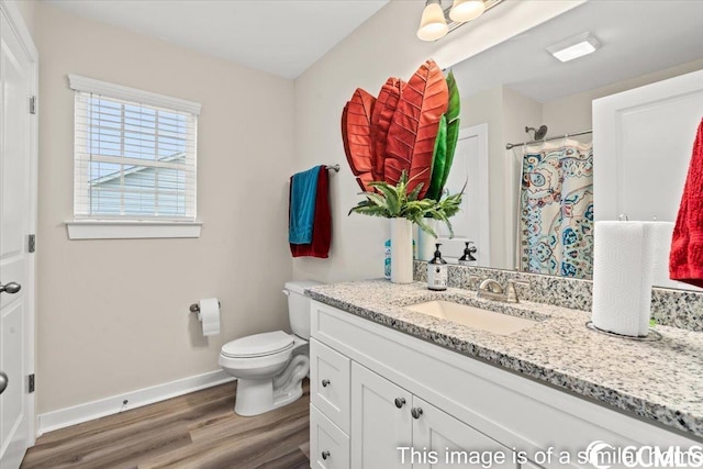 full bath featuring a shower with curtain, toilet, wood finished floors, baseboards, and vanity