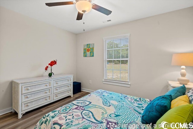 bedroom with visible vents, baseboards, wood finished floors, and a ceiling fan