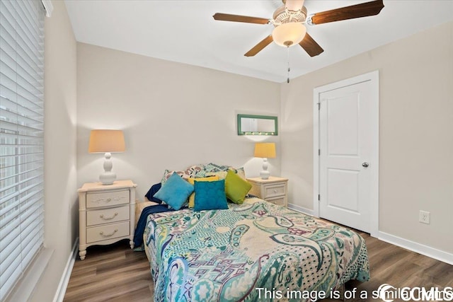 bedroom featuring baseboards, wood finished floors, and a ceiling fan