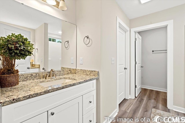 bathroom with vanity, baseboards, and wood finished floors