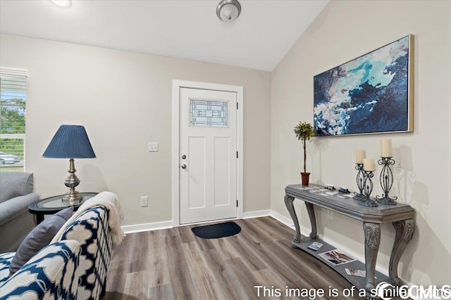 foyer entrance with baseboards, lofted ceiling, and wood finished floors