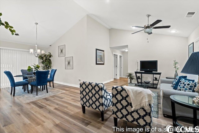 living area featuring visible vents, baseboards, light wood-style floors, and high vaulted ceiling