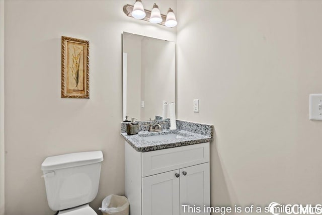 half bathroom featuring toilet and vanity