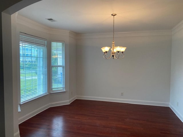 empty room featuring an inviting chandelier, plenty of natural light, ornamental molding, and dark hardwood / wood-style floors